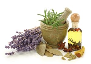 Jar of oil, rosemary in a mortar and pestle, herbs, and lavender representing holistic homeopathic solutions at The Healing Narrative